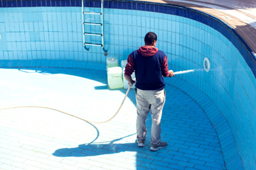 pool contractor cleaning a pool